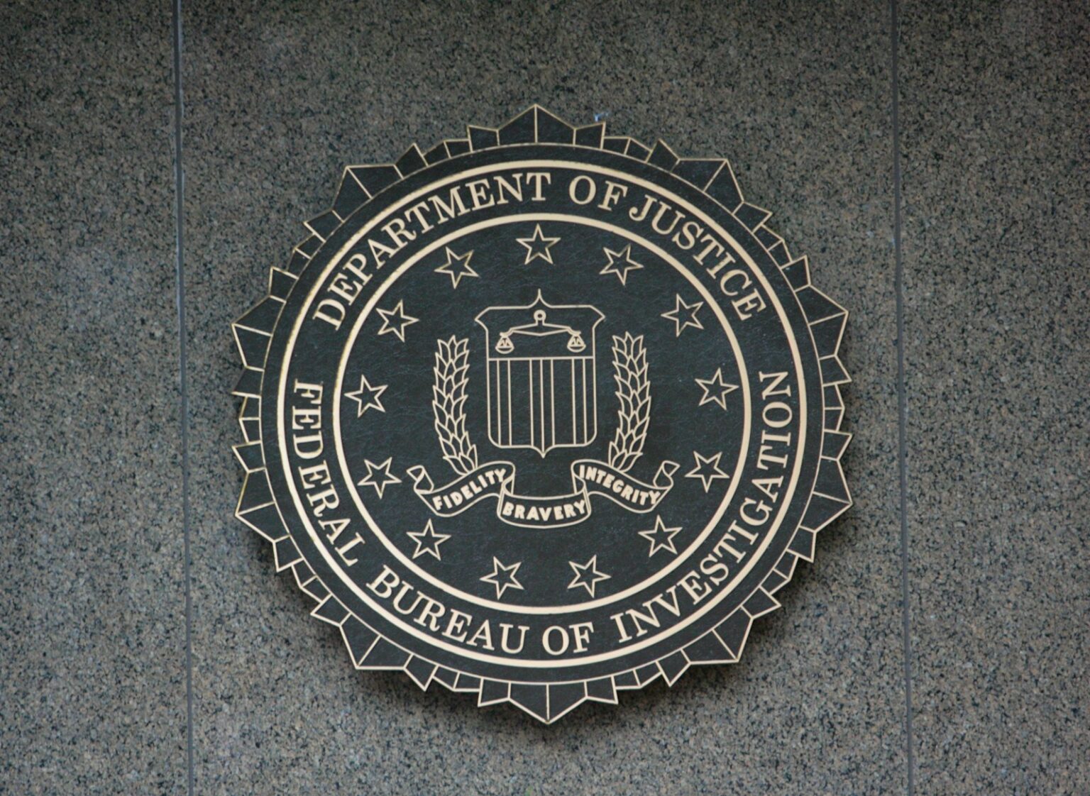 the seal of the department of justice and FBI on a wall